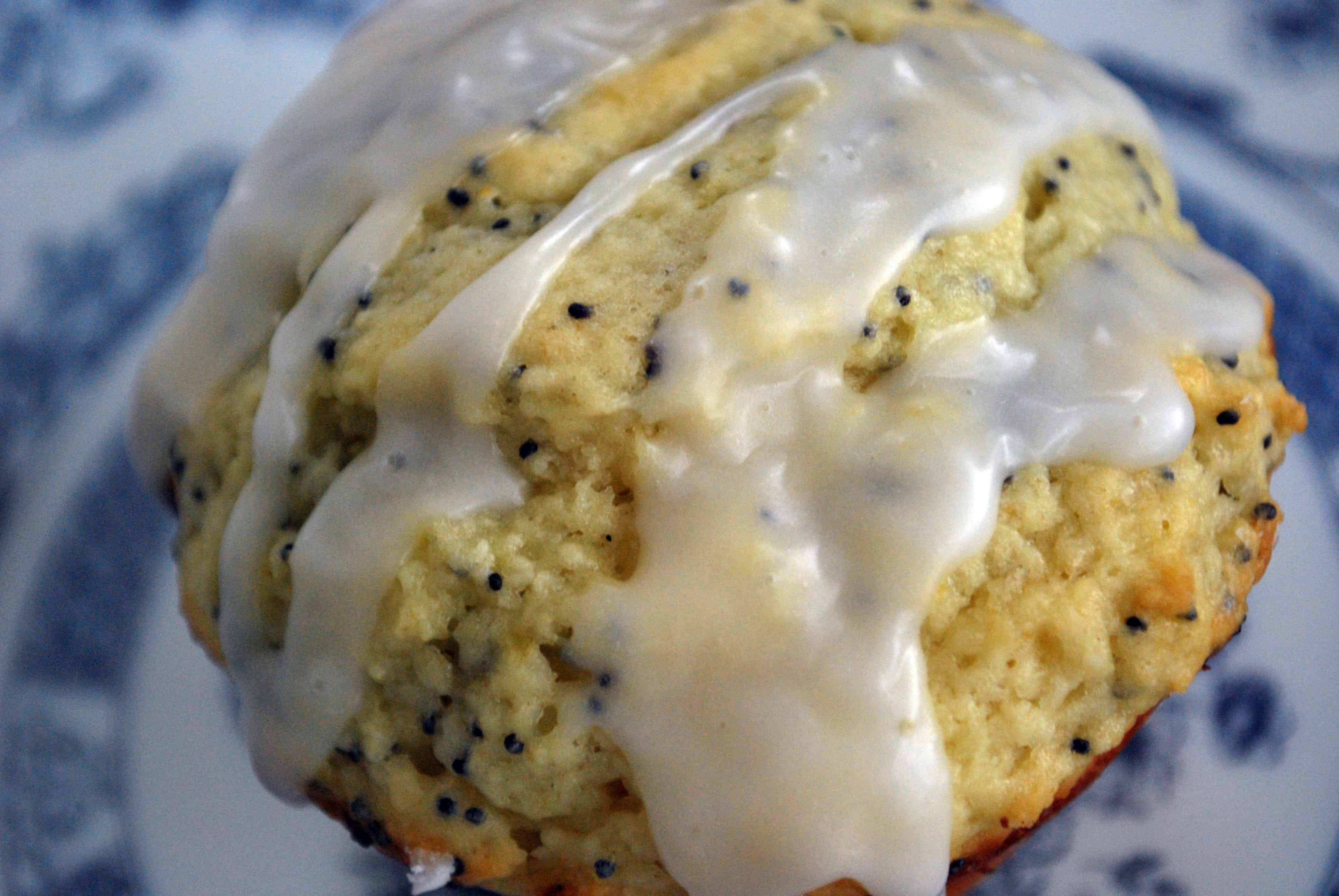 LemonPoppyseedMuffinsEXU a close up of Lemon Poppy Seed Muffin topped with glaze on a blue and white patterned plate