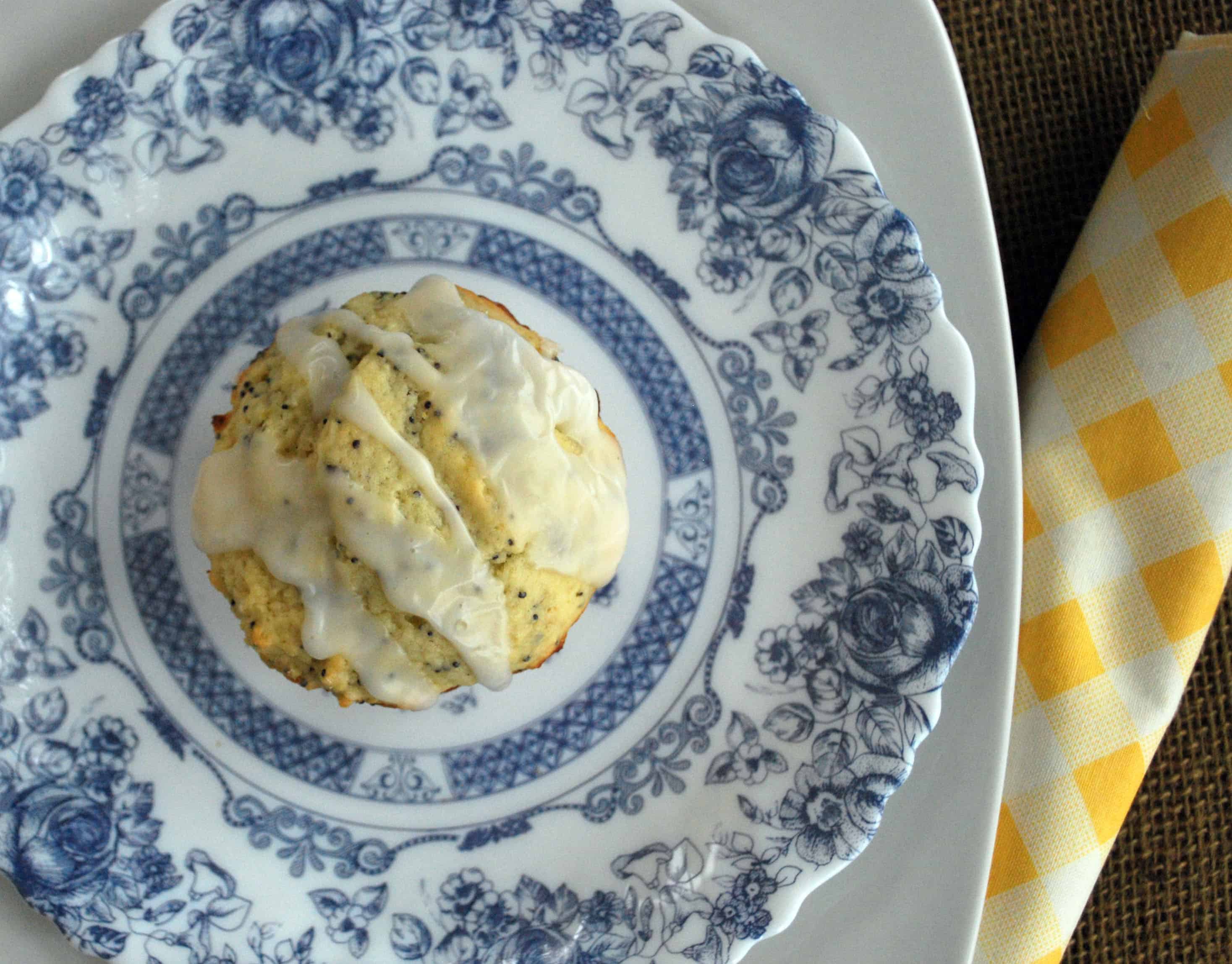 LemonPoppyseedMuffinsOH top view of a Lemon Poppy Seed Muffin topped with glaze on a blue and white patterned plate