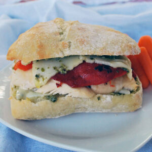 a pesto chicken sandwich on a white plate