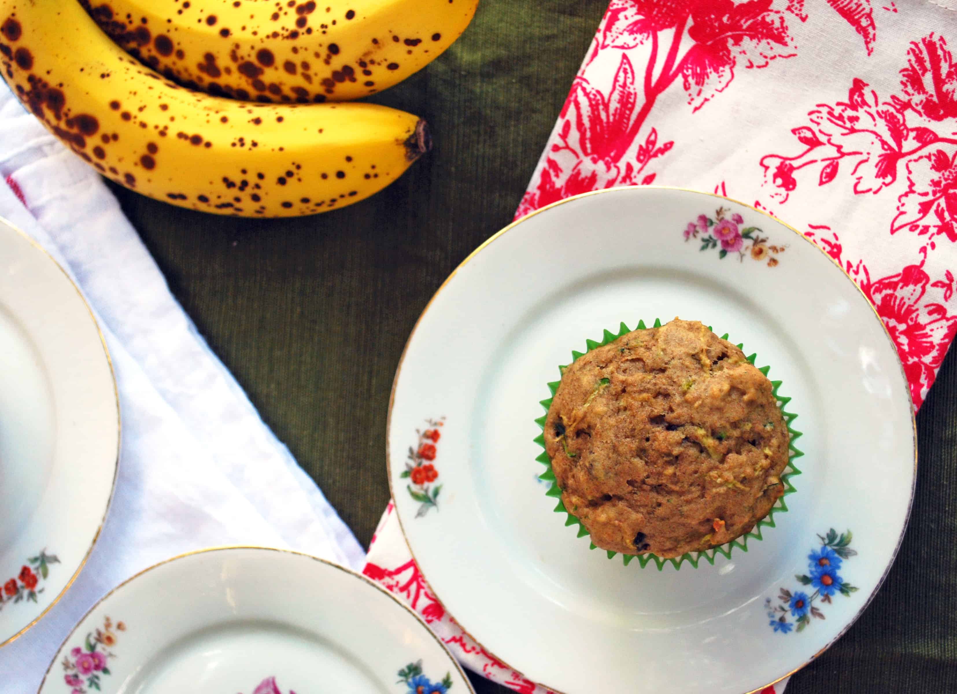 Zuchinni Banana Chocolate Chip Muffins top view of a zuchinni Banana Chocolate Chip Muffin next to a banana