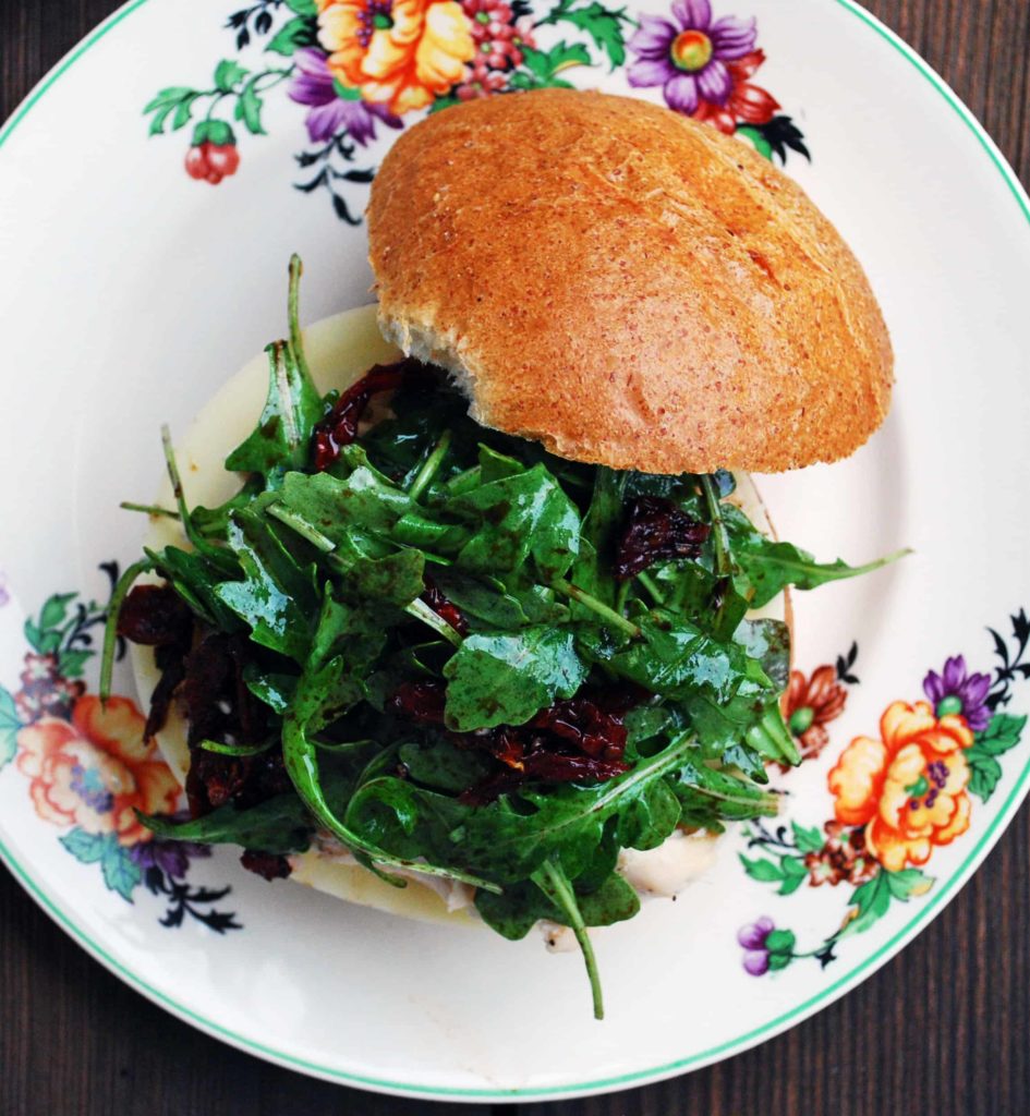 Balsamic and Sun-Dried Tomato Sandwich on a white plate with a floral border.
