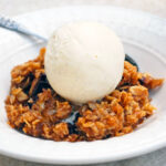 Chocolate Banana Crisp on a plate with a scoop of vanilla ice cream