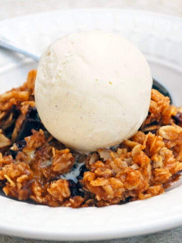 Chocolate Banana Crisp on a plate with a scoop of vanilla ice cream