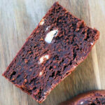 a frozen cream cheese brownie on a wood cutting board