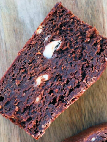 a frozen cream cheese brownie on a wood cutting board