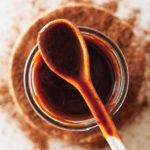 a spoon and jar with spicy bbq sauce