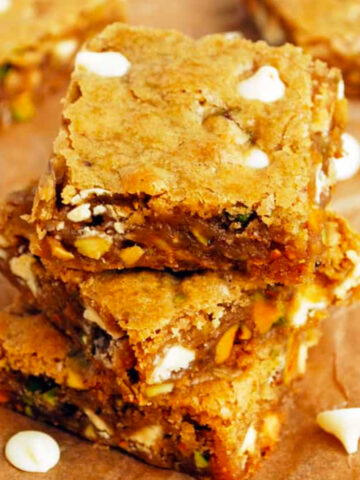 a stack of three white chocolate pistachio blondies.