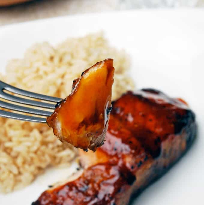 a fork grabbing a bite of grilled teriyaki salmon
