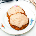 two summer squash cookies topped with cinnamon frosting on a plate