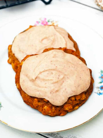 two summer squash cookies topped with cinnamon frosting on a plate