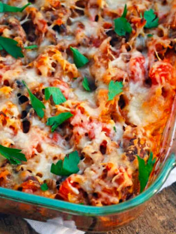 Spaghetti squash casserole in a glass pan on a wood background.