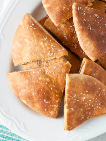Baked pita chips on a white plate.