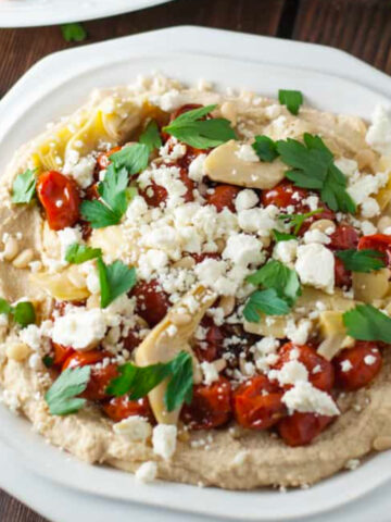 Loaded hummus on a white plate.