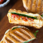 a cheesy hummus panini cut in half to show the inside