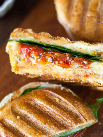 a cheesy hummus panini cut in half to show the inside