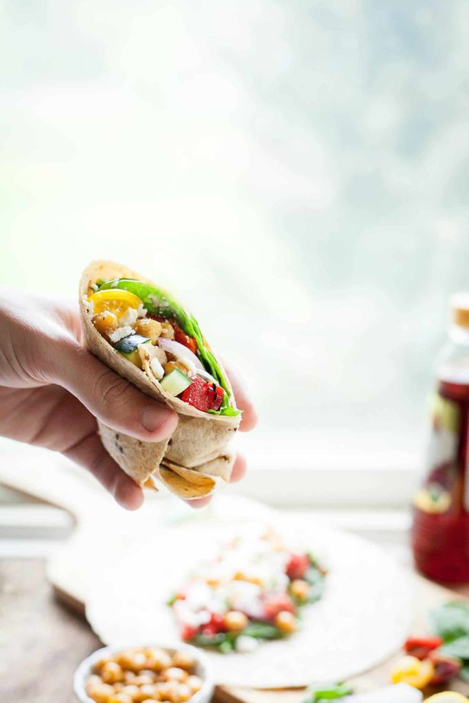 Greek Chickpea Wraps - This easy sandwich is filled with roasted chickpeas, crunchy veggies, and tangy feta cheese! I love taking these on the go. theliveinkitchen.com