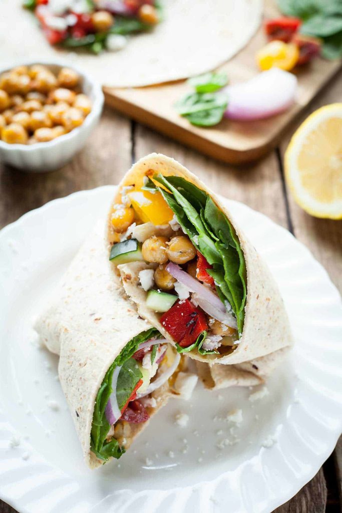 Greek Chickpea Wraps - This easy sandwich is filled with roasted chickpeas, crunchy veggies, and tangy feta cheese! I love taking these on the go. theliveinkitchen.com