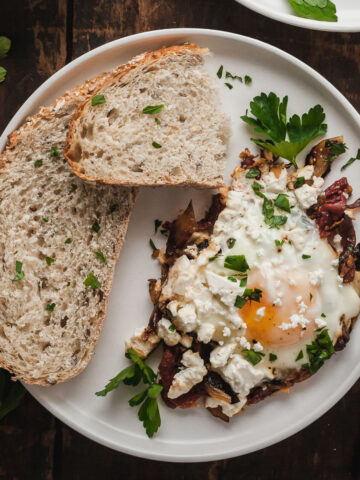 mediterranean eggs on a plate next to slices of toast