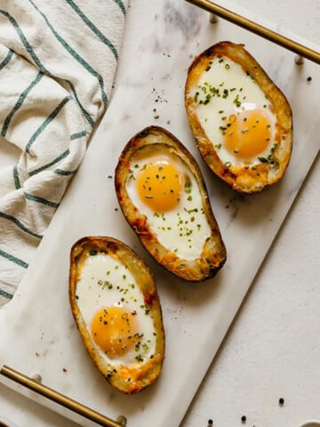 three potato skin egg boats on a platter