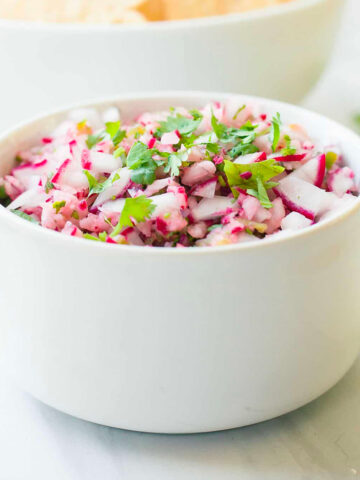 a bowl of radish salsa and a bowl of tortilla chips.