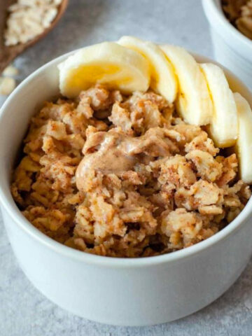 close up image of small white bowl with vegan baked oatmeal and ingredients in background
