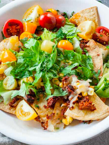 close up image of a bowl with vegetarian chorizo nachos with lime crema.