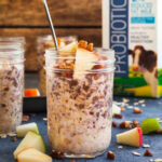 a jar of apple cinnamon overnight oatmeal with apple chunks and a jug of milk.
