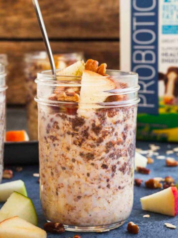 a jar of apple cinnamon overnight oatmeal with apple chunks and a jug of milk.