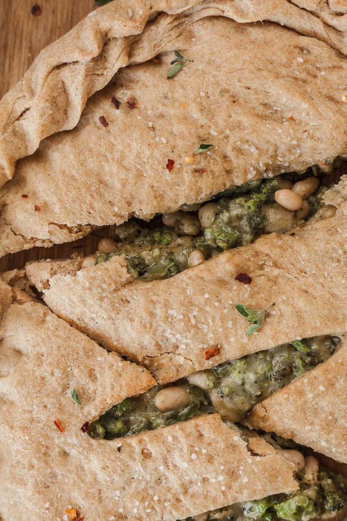 Broccoli, Bean, and Cheese Vegetarian Calzone - An easy meatless dinner recipe that comes together fast if you use store bought dough! #vegetarian #calzone #beans #broccoli #pesto #cheese