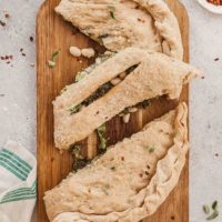 Broccoli, Bean, and Cheese Vegetarian Calzone - An easy meatless dinner recipe that comes together fast if you use store bought dough! #vegetarian #calzone #beans #broccoli #pesto #cheese