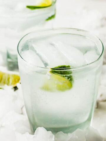 two gin and tonics with limes and ice