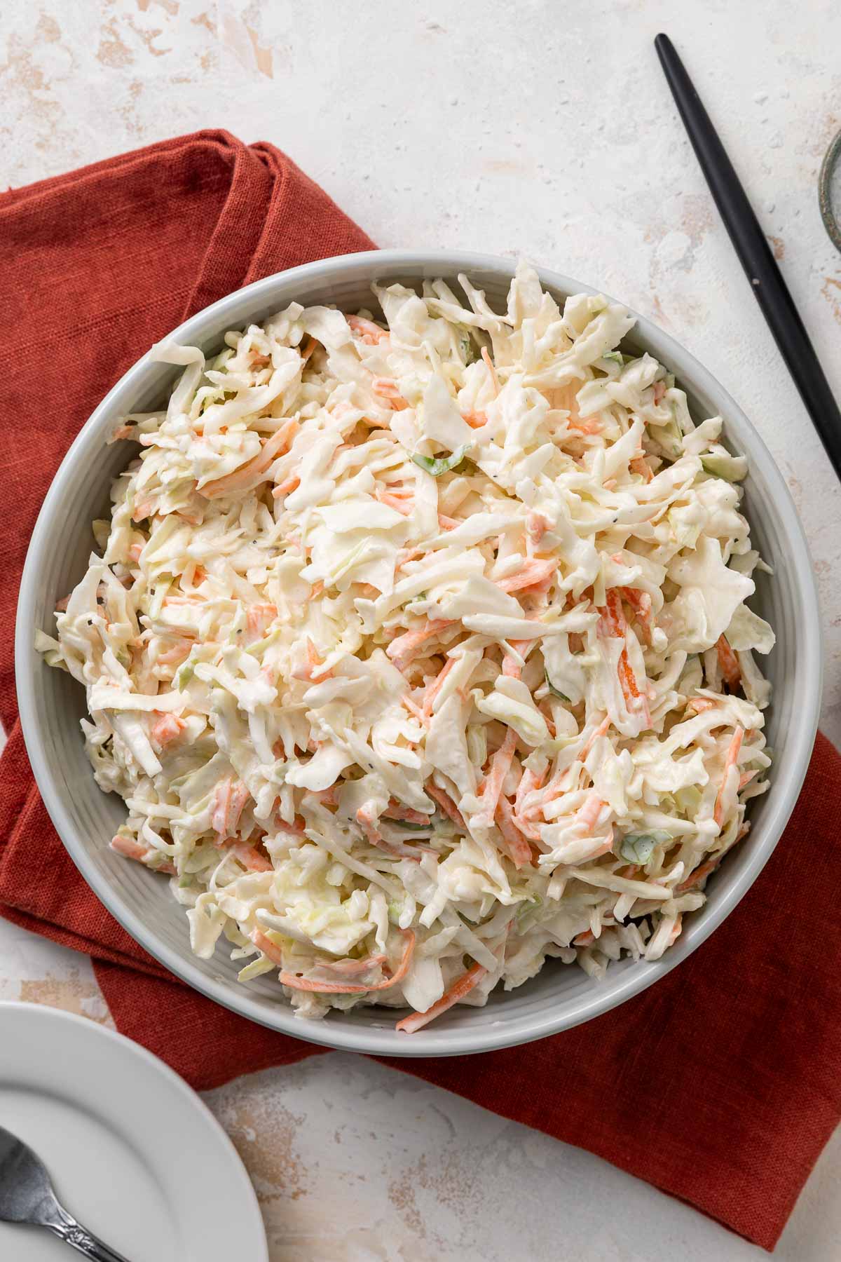 A bowl of no-mayo coleslaw on a red linen napkin.