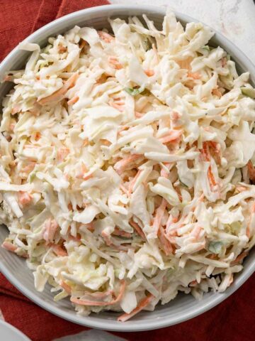 A bowl of no-mayo coleslaw on a red linen napkin.