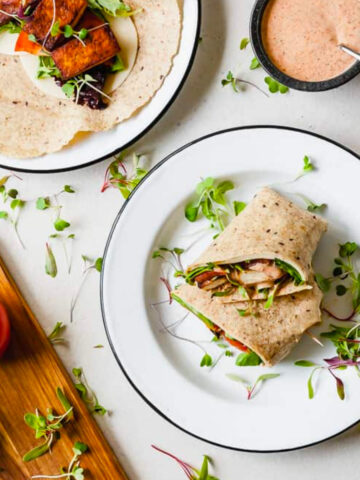 a cajun wrap cut in half on a white plate.