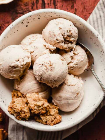 scoops of cinnamon oatmeal ice cream in a speckled bowl.