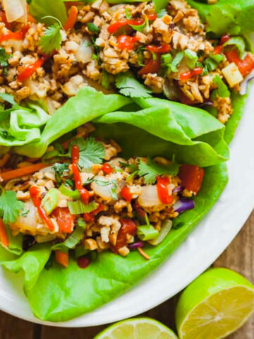 close up of lettuce wraps with limes on the table