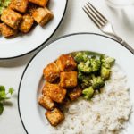 crispy tofu on a white plate with broccoli and rice