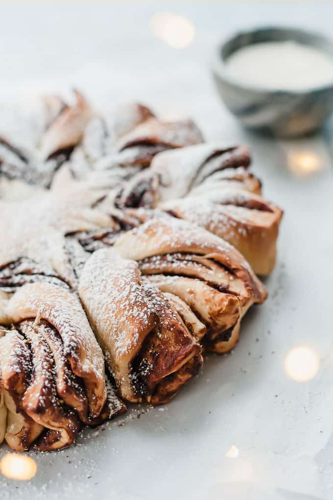 chocolate pistachio christmas star bread on a white table with twinkle lights