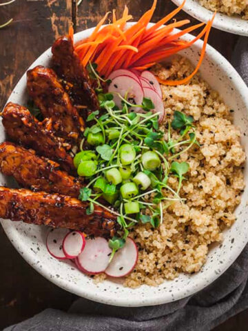 vegan tempeh buddha bowl on a wood table.
