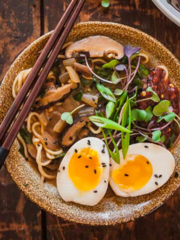 A bowl of vegetarian ramen with chopsticks on the side.
