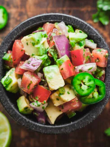 Pico de Gallo with avocado in a small stone bowl.