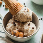 scoops of vegan chocolate chip cookie dough ice cream in a bowl with a cone.