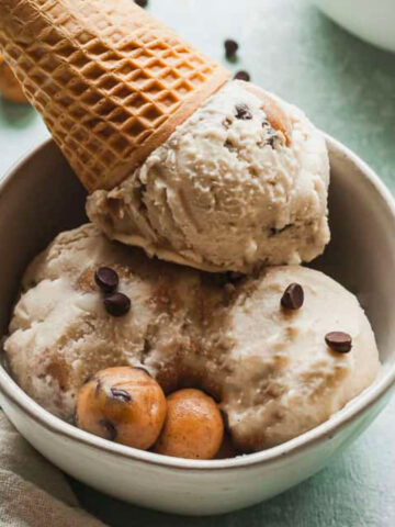 scoops of vegan chocolate chip cookie dough ice cream in a bowl with a cone.
