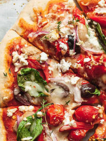 greek pizza slices on a baking sheet