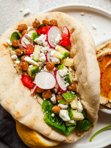 overhead photo of a double bean pita sandwich with a bowl of bean dip.
