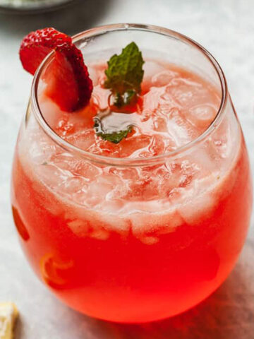 strawberry lemonade vodka in a glass with strawberries and mint