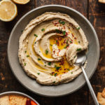 a bowl of basic hummus with a spoon