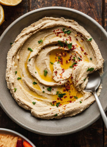 a bowl of basic hummus with a spoon