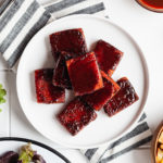 bbq tofu on a white plate with a striped towel