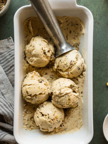 a white dish with scoops of pistachio ice cream